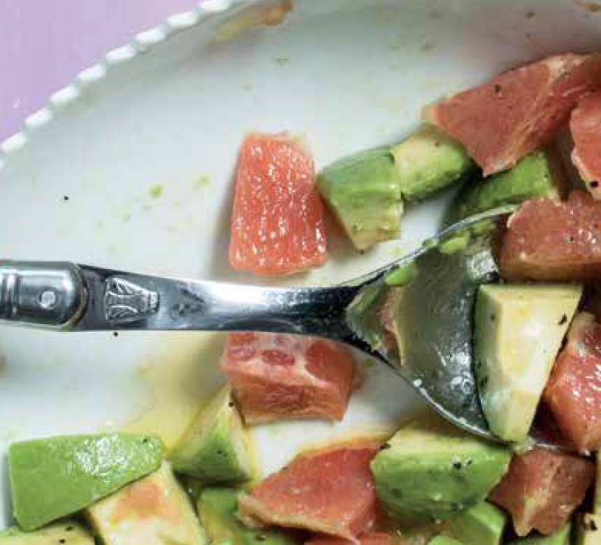 Bowl of avocado and grapefruit salad with spoon